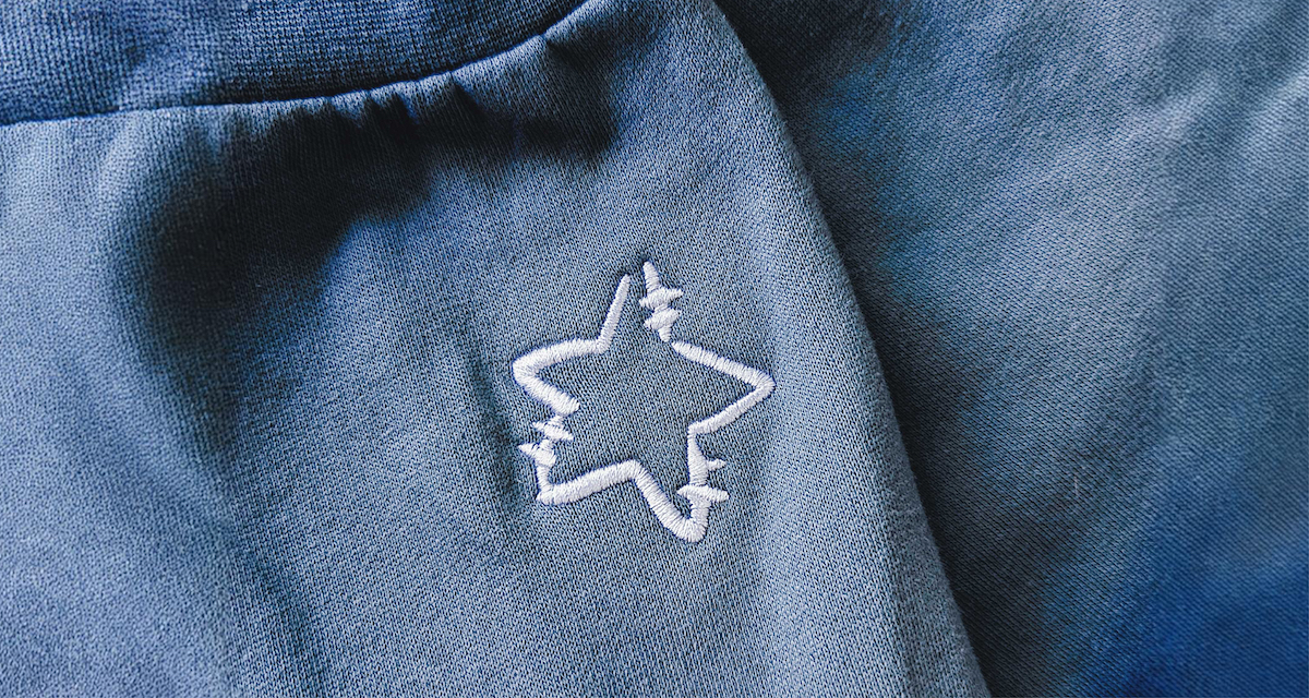 A close-up of a stitched star icon on a blue sweatshirt